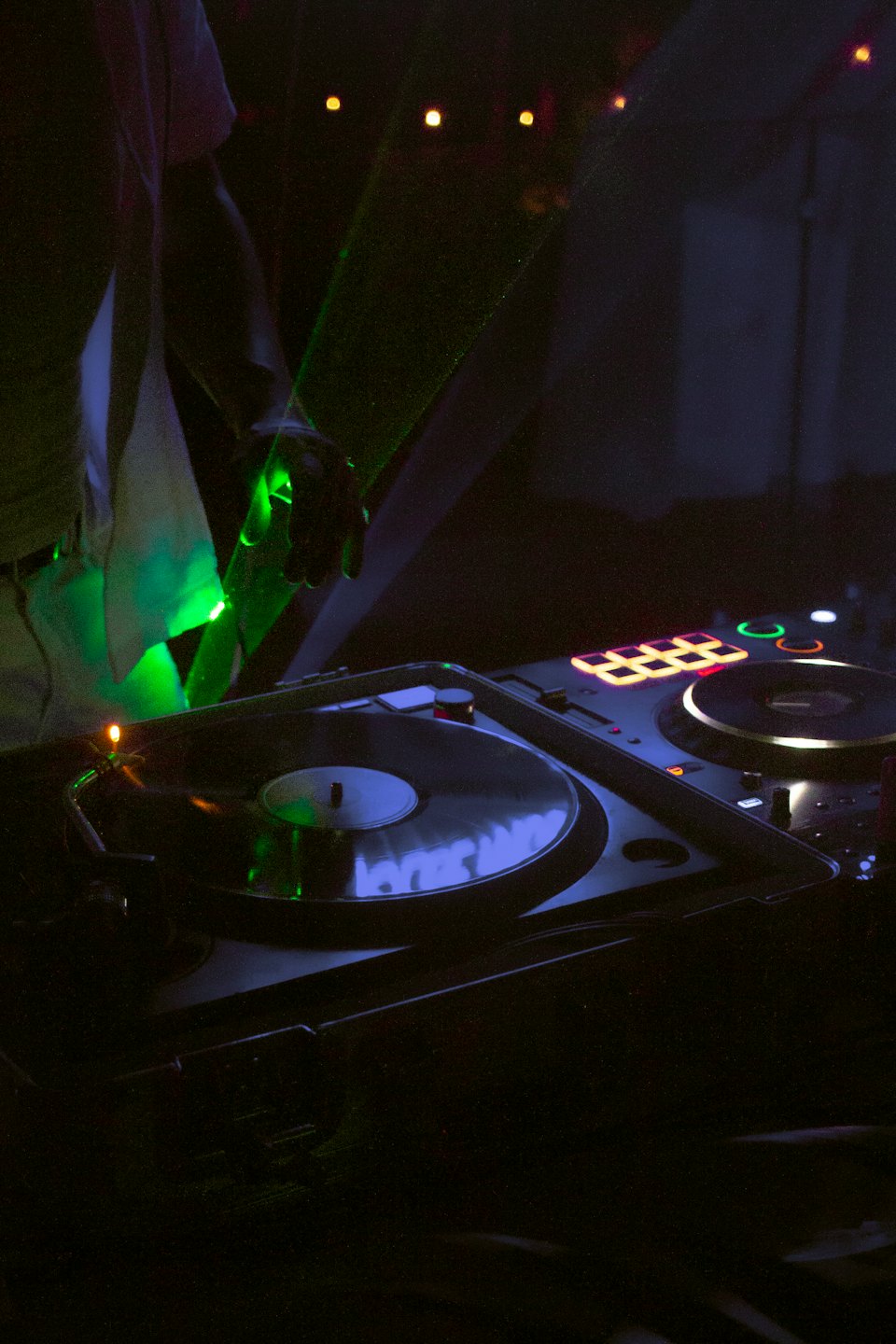 DJ-Hände stellen eine Schallplatte auf einem Plattenspieler ein.